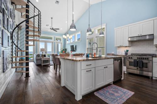 a large kitchen with white cabinets and a kitchen island at Bay Reserve in Rockport