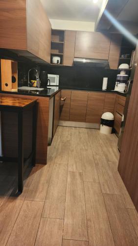 a kitchen with wooden cabinets and a wooden floor at Apartamento Granat, con parqueo en Cuatro grados norte in Guatemala
