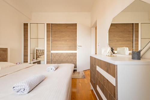 a bedroom with two beds and a sink and a mirror at Apartment 5 in Pristina