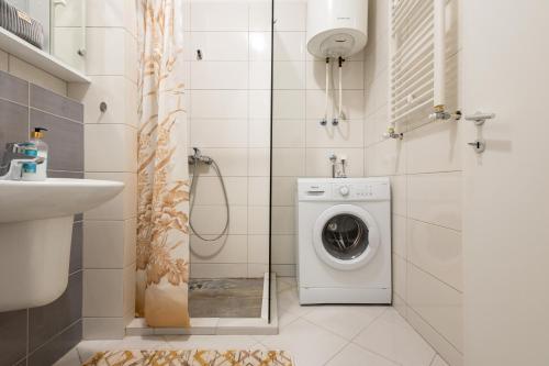 a bathroom with a washing machine and a sink at Apartment 5 in Pristina