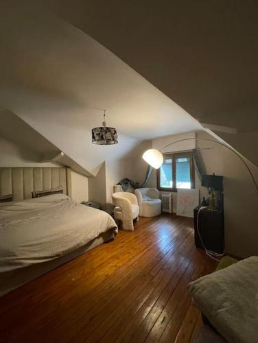 1 dormitorio con 1 cama, 1 silla y 1 lámpara en Maison 20 min de PARIS 