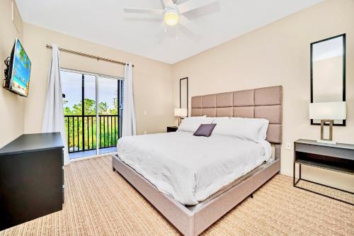 a bedroom with a bed and a large window at Bright 2BR Condo with Pool and Hot tub - near Disney! in Orlando