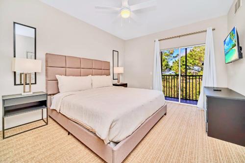 um quarto com uma cama grande e uma televisão em Spacious 2BR Condo with Pool & Hot tub, near Disney! em Orlando