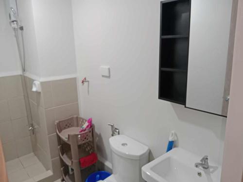a white bathroom with a toilet and a sink at MJC's Stay and Relax in Marilao