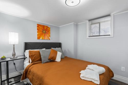 a bedroom with a bed with orange and white pillows at 2 Bedroom with Laundry and Parking in Windsor in Windsor