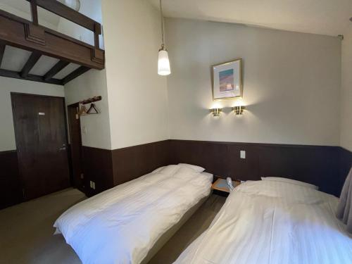 two beds in a room with at Poetical in Matsumoto