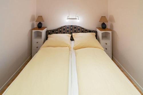 een slaapkamer met een groot bed met 2 nachtkastjes bij Fewo-Mientje-2-Haustiere-erlaubt-WLAN-kostenlos in Norddeich