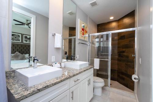 a bathroom with two sinks and a shower at Magical Themed House Just 5 Minutes to Disney Free BBQ Pool Access in Orlando