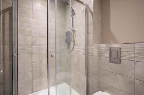 a shower with a glass door in a bathroom at Skyline Serenity: Exquisite 3-Bedroom Ultra-Luxury Penthouse in Belfast