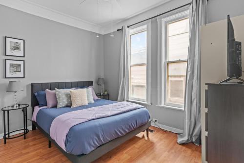 um quarto com uma cama e duas janelas em Stylish 2bd, DT, Lndry & Prkng em Windsor