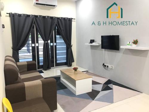a living room with a homesay sign on the wall at A&H Homestay Teluk Intan in Teluk Intan