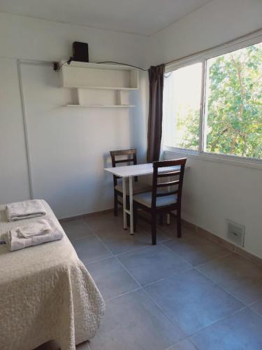 um quarto com uma mesa e cadeiras e uma janela em Hermoso monoambiente en ciudad de Mendoza. em Mendoza