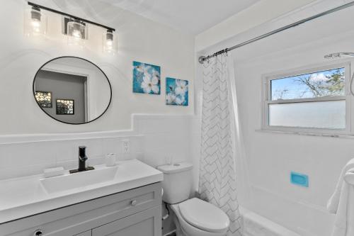 a white bathroom with a sink and a mirror at Cheerful Family Home - 3 mins drive to UWindsor in Windsor