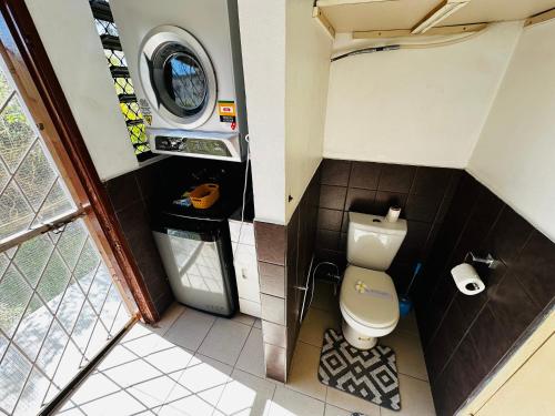 a small bathroom with a toilet and a washing machine at Cozy, Comfortable, Family Home. in Nadi