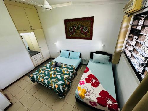um quarto com duas camas e um espelho em Cozy, Comfortable, Family Home. em Nadi