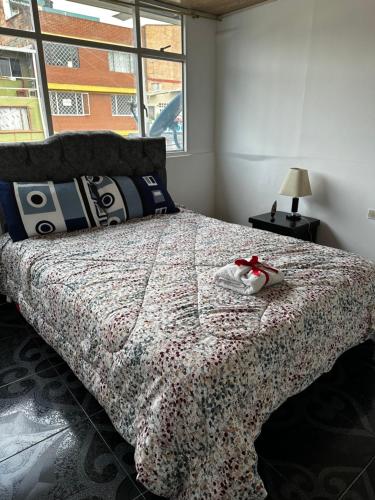 a bedroom with a bed with a red ribbon on it at Apartamento cerca al centro y sitios turísticos in Bogotá