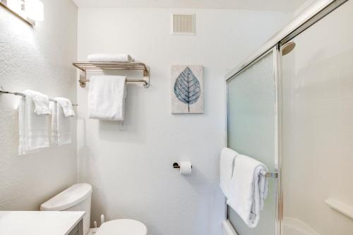 a white bathroom with a shower and a toilet at 2 Mi to Beaches and Trails Tahoe Area Home with Sauna in Stateline