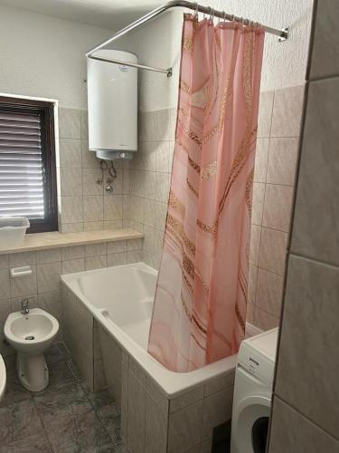 a bathroom with a tub and a toilet and a shower curtain at Apartments by the sea Slatine, Ciovo - 1128 in Slatine
