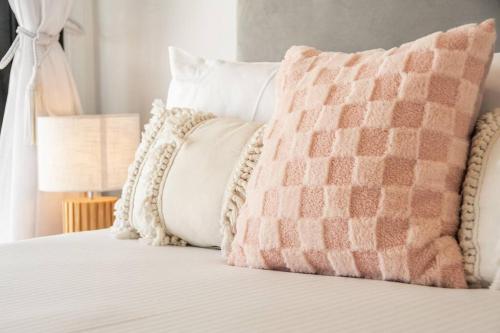 a bed with two pillows on top of it at Sophie's Place ReLaunch - Luxury Penthouse in Byron Bay