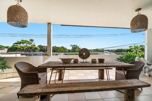 a wooden table and chairs on a balcony with a view at Sophie's Place ReLaunch - Luxury Penthouse in Byron Bay