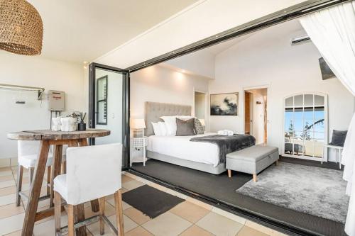 a bedroom with a bed and a table in a room at Sophie's Place ReLaunch - Luxury Penthouse in Byron Bay