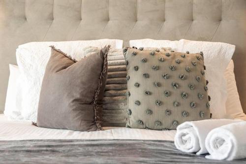 a bed with pillows and pillows on it at Sophie's Place ReLaunch - Luxury Penthouse in Byron Bay