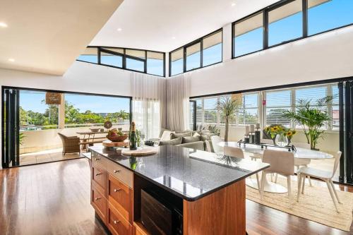an open kitchen and living room with large windows at Sophie's Place ReLaunch - Luxury Penthouse in Byron Bay