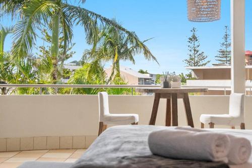 a bedroom with a view of a balcony with a table and chairs at Sophie's Place ReLaunch - Luxury Penthouse in Byron Bay
