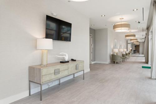 a lobby with a dresser and a tv on a wall at EVEN Hotel Austin Uptown near the Domain by IHG in Austin