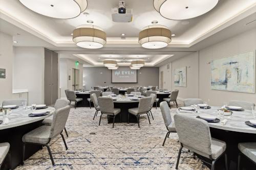 a conference room with tables and chairs and a projection screen at EVEN Hotel Austin Uptown near the Domain by IHG in Austin