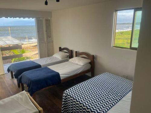 Duas camas num quarto com vista para o oceano em Casa Beira Mar Barra Sirinhaem em Sirinhaém