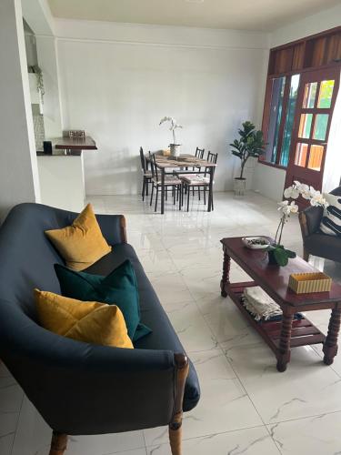 un soggiorno con divano blu e tavolo di “Marley’s Home“ a Lautoka