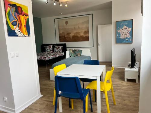 un salon avec une table blanche et des chaises jaunes dans l'établissement 011 CHIC & COSY STUDIO 40m2 HYPERCENTRE WIFI SMART TV NETFLIX, à Saint-Étienne