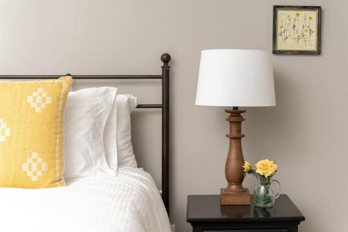 a bedroom with a bed with a lamp on a table at Luxurious, Modern Farmhouse in Wine Country in Atascadero