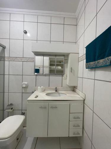 a white bathroom with a sink and a toilet at Apto 3 otimo Local próximo Shopping in Campo Grande