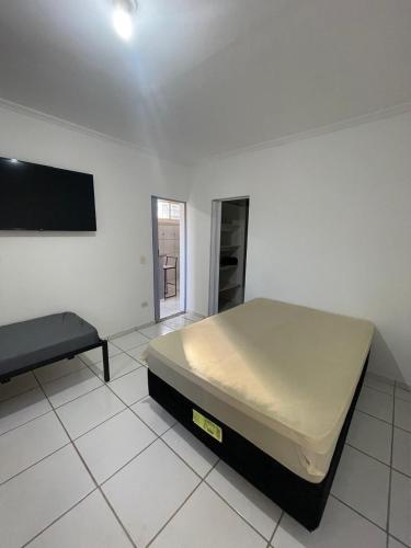 a bedroom with a bed and a tv on the wall at Apto 3 otimo Local próximo Shopping in Campo Grande