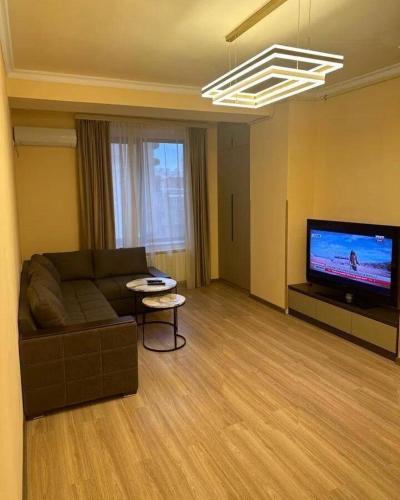 a living room with a couch and a flat screen tv at Graz Adam Relax Villa 2 in Joniškis