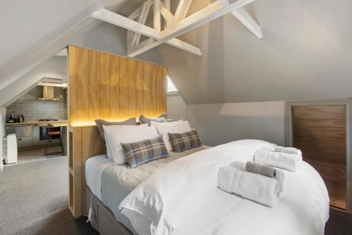 um quarto com uma grande cama branca com toalhas em Judge & Jury Farm Retreat em Gibbston