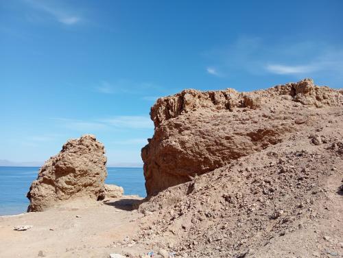 a rock formation on the shore of the ocean at Not a real Hotel in Dahab
