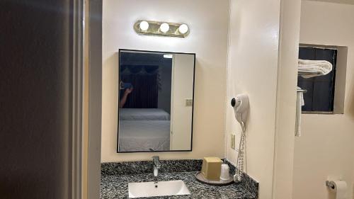 a bathroom with a sink and a mirror at Deluxe Inn Of Roswell in Roswell