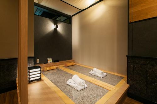 een kamer met twee witte handdoeken op de vloer bij Hotel Ritmo & Gessy ラブホテル in Fukuoka