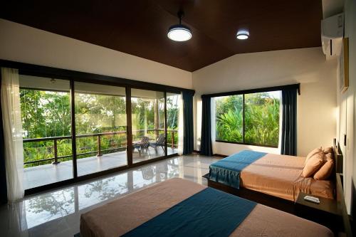 a bedroom with two beds and a large window at Eden Corcovado in San Pedrillo