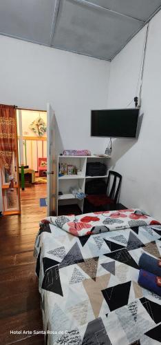 a bedroom with a bed with a quilt on it at Hotel Arte Santa Rosa in Santa Rosa de Cabal
