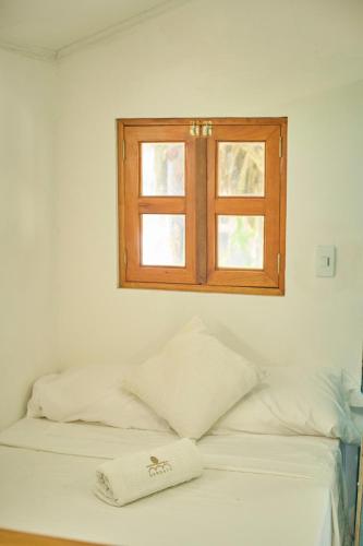 a bed with a window and a towel on it at Mangata Beach in Cartagena de Indias