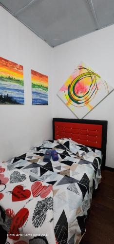a bedroom with a bed with a colorful quilt on it at Hotel Arte Santa Rosa in Santa Rosa de Cabal