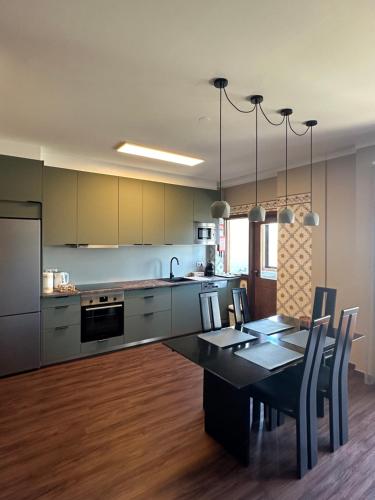 a kitchen with a table and a dining room at aerOPOrto Guesthouse in Maia