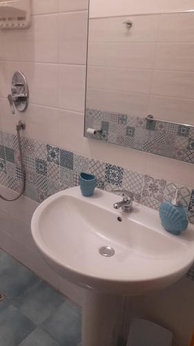 bagno con lavandino bianco e specchio di Villa Diana a Capoliveri