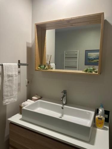 a bathroom with a white sink and a mirror at aerOPOrto Guesthouse in Maia