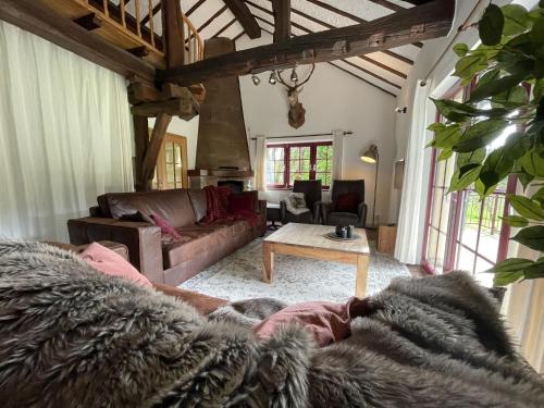 een woonkamer met een bank en een tafel bij Ardennes villa with riverside garden and views in Atzerath
