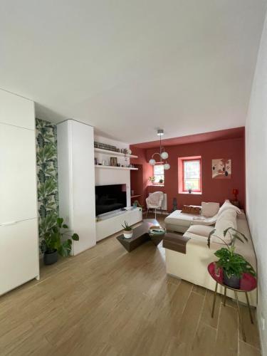 uma sala de estar com um sofá branco e paredes vermelhas em Élégant 2 chambres à deux pas de l'Espagne em Urrugne
